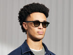 El modelo lleva el DOLT SUN en Dark Green en talla 49 con lentes tintados Forest Wood.