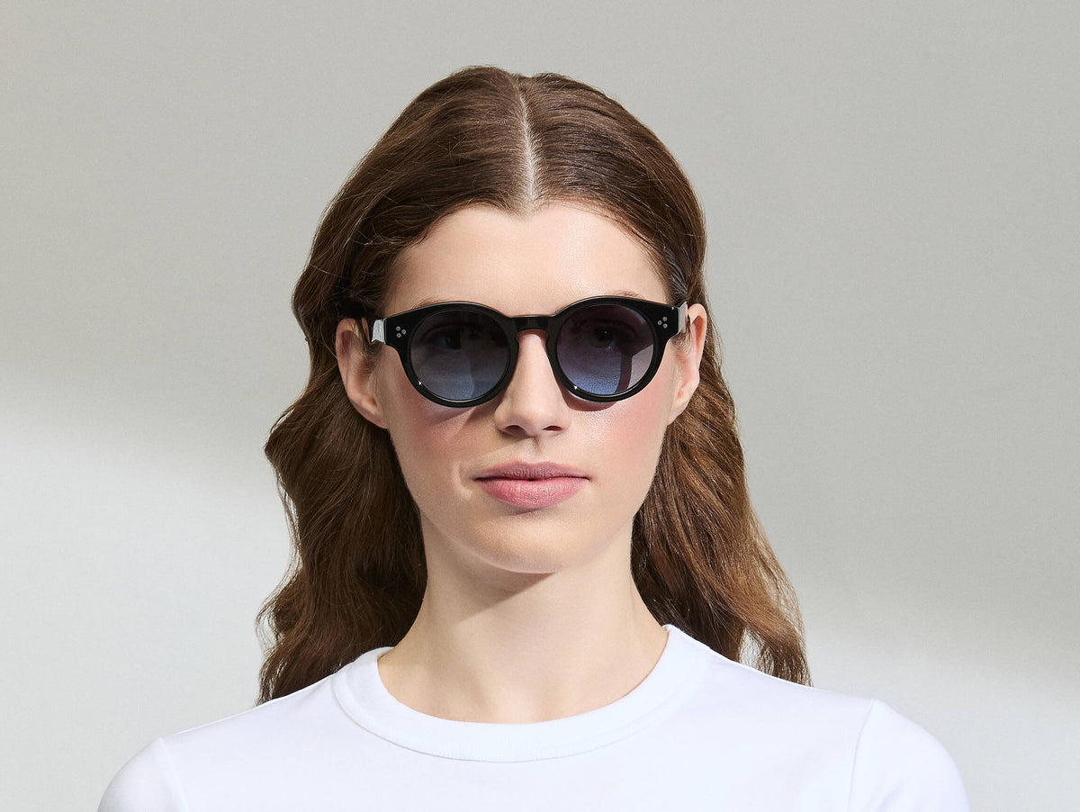 Model is wearing The GRUNYA SUN in size 47 in Black with Denim Blue Tinted Lenses