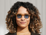 La modella indossa il LEMTOSH in Blonde nella taglia 46 con lenti Celebrity Blue Tinted.