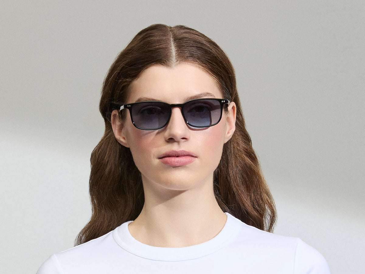 Model is wearing The LIKTIG SUN in size 53 in Black with Denim Blue Tinted Lenses
