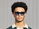 El modelo lleva el RIZIK en Black en talla 49 con lentes tintadas Broadway Blue Fade.