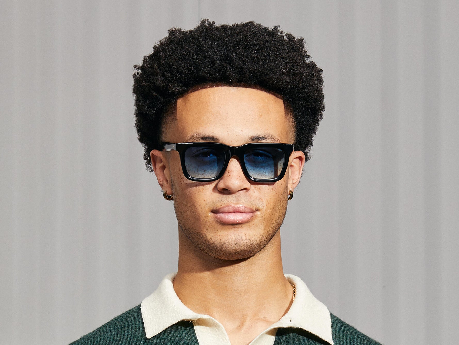 El modelo lleva el RIZIK en Black en talla 49 con lentes tintadas Broadway Blue Fade.